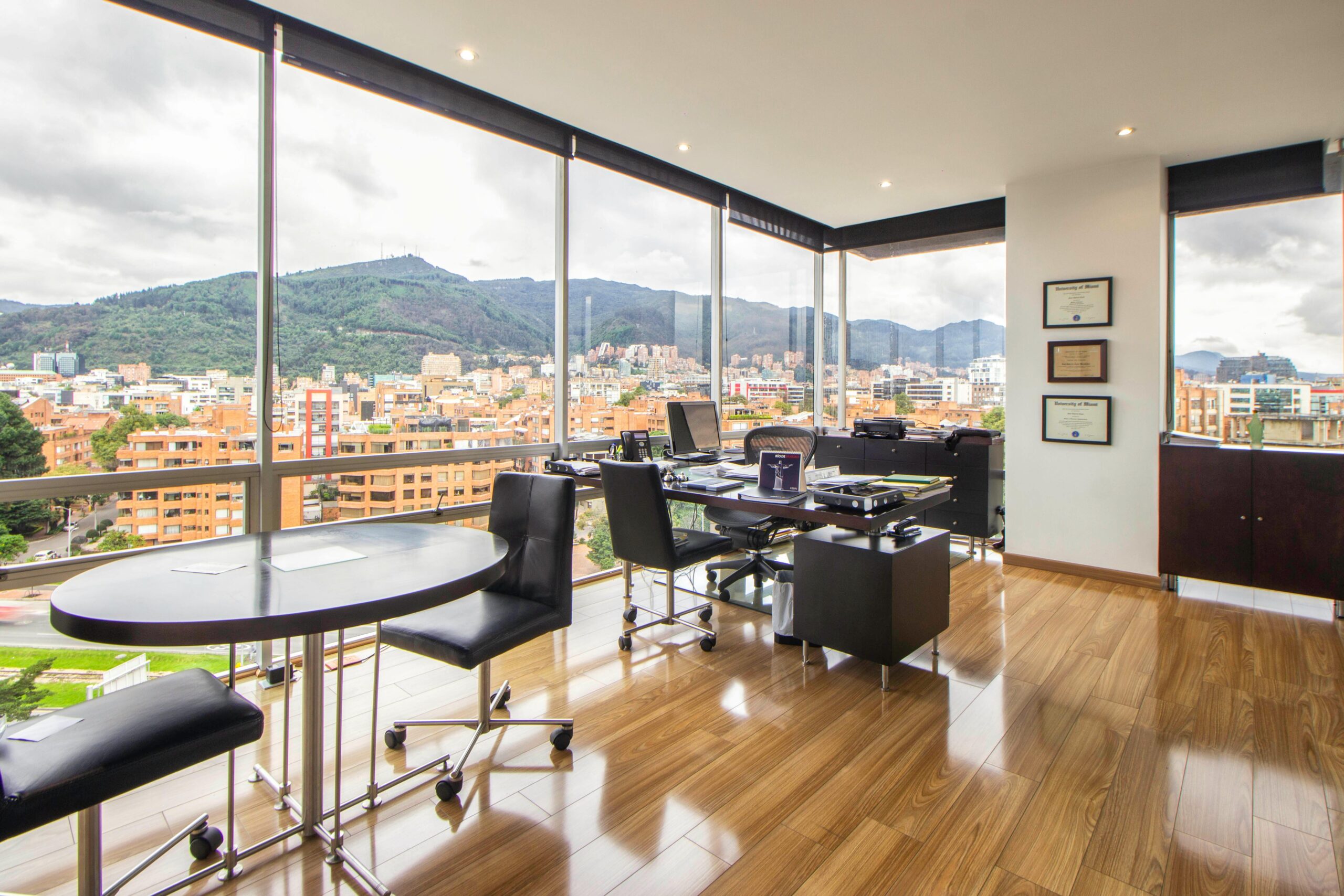Spacious modern office with a scenic city view through glass windows.